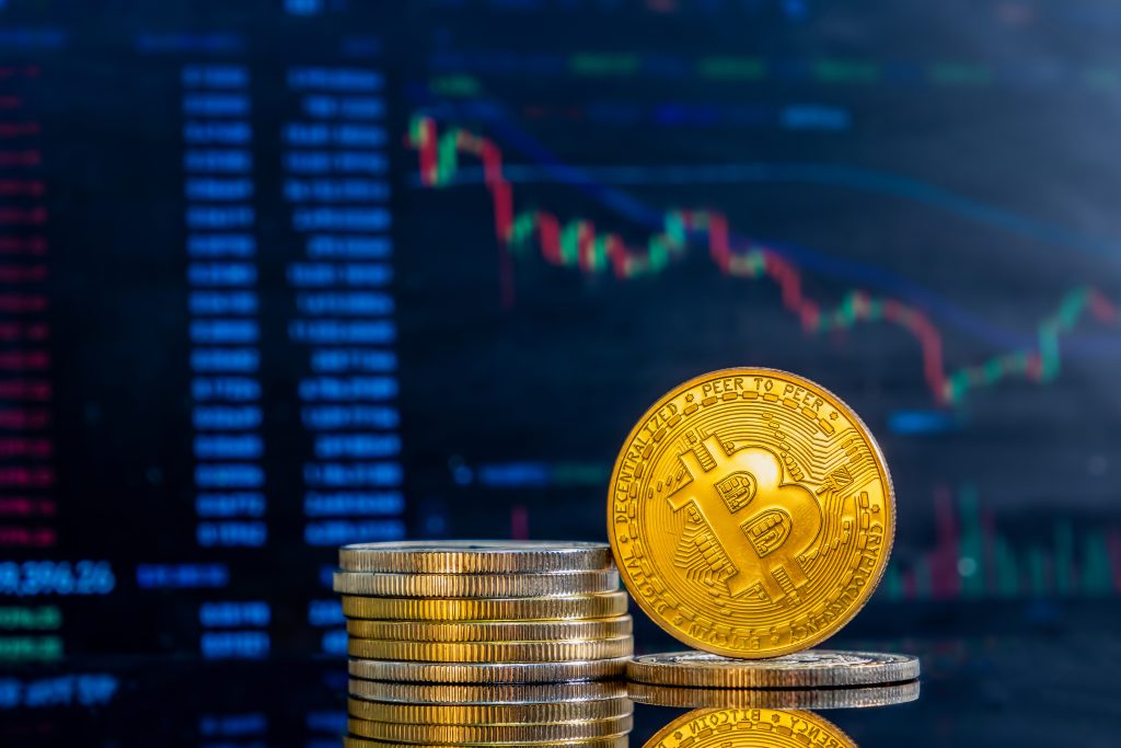 Bitcoin coins in front of an economic graphic