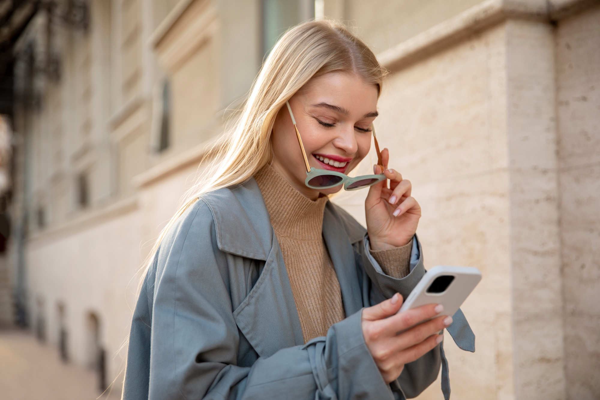 A woman smiling at her phone