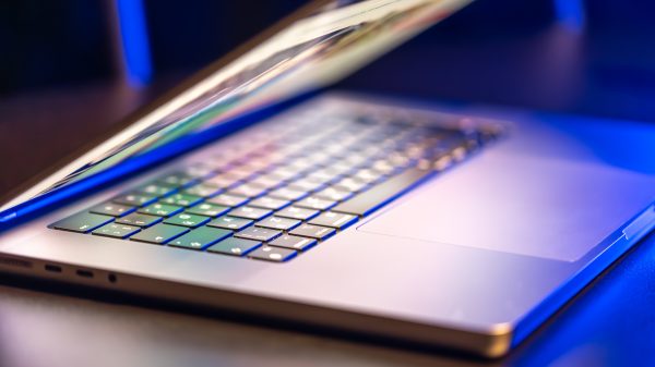 A laptop computer with a half-open screen on a dark background