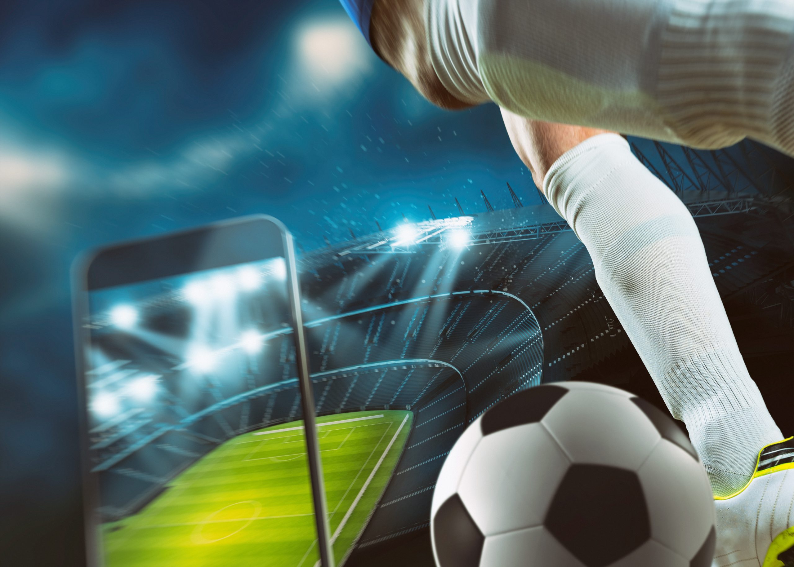 Soccer player, cellphone and ball on a stadium