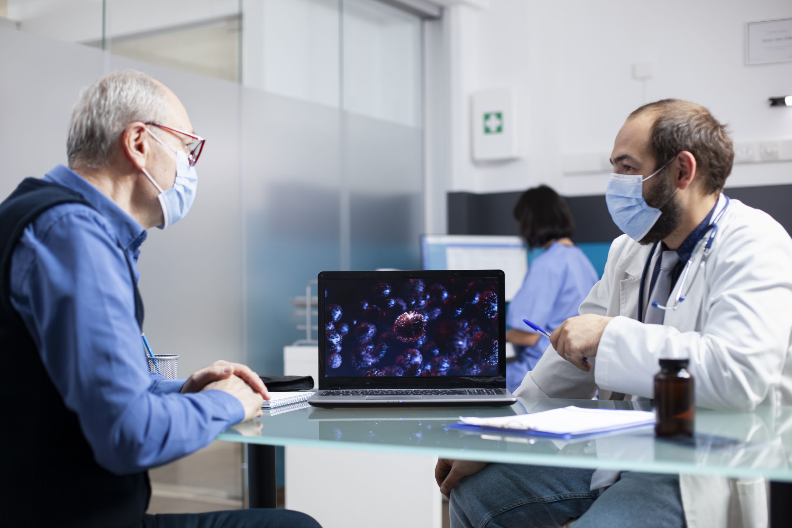 Physician explains sickness prevention to senior man,